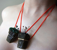Alchemy life-form on silver and red rubber tubing necklace attachment.